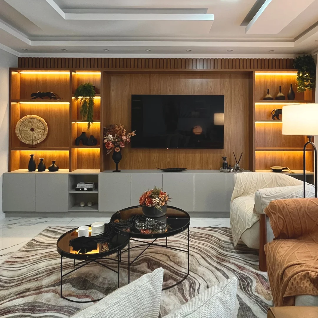 Sala com painel de TV amadeirado e nichos iluminados