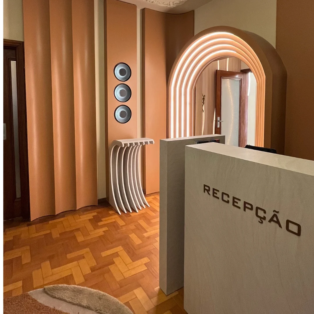 Recepção com painel de madeira, formas curvas e iluminação integrada